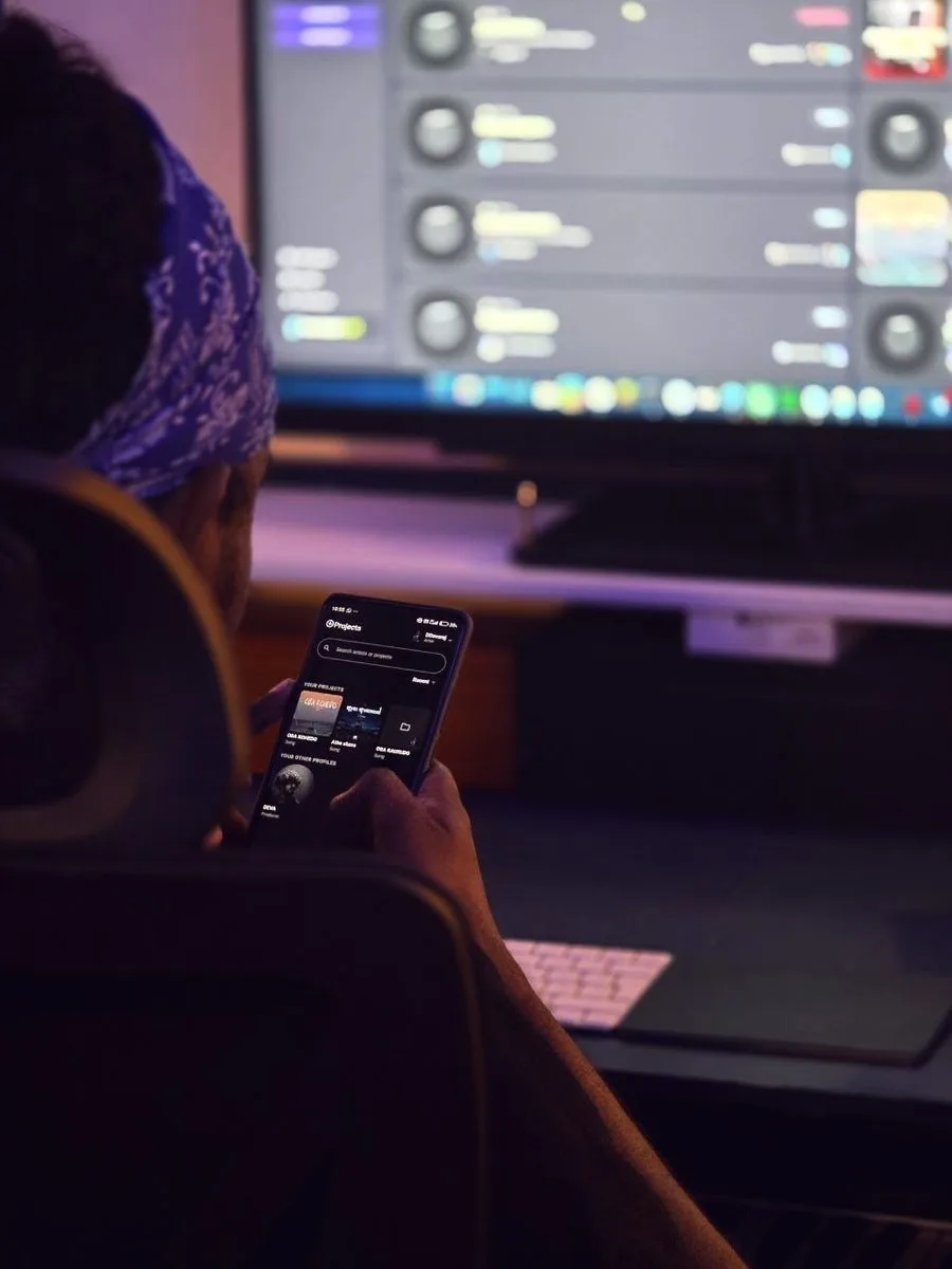 Artist checking TrackSpace on his phone at the studio desk